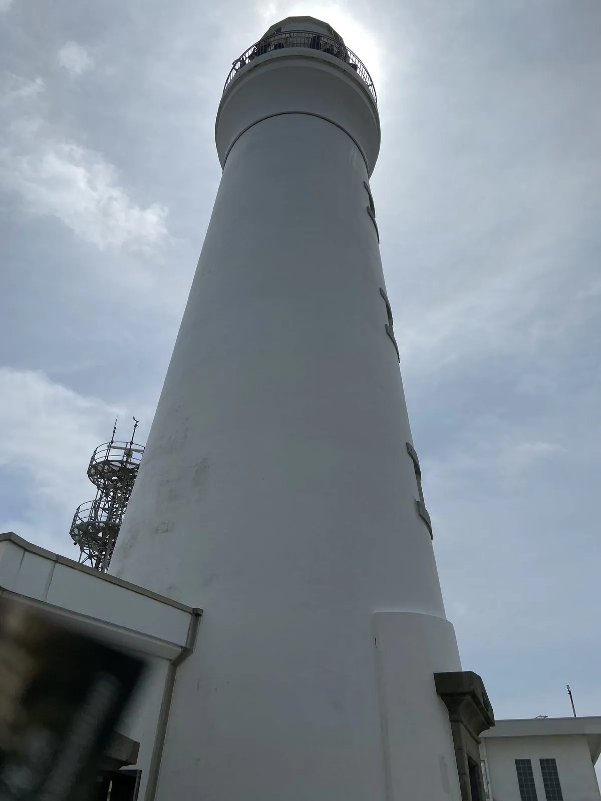 Looking up at the white Inubosaki Lighthouse from its base