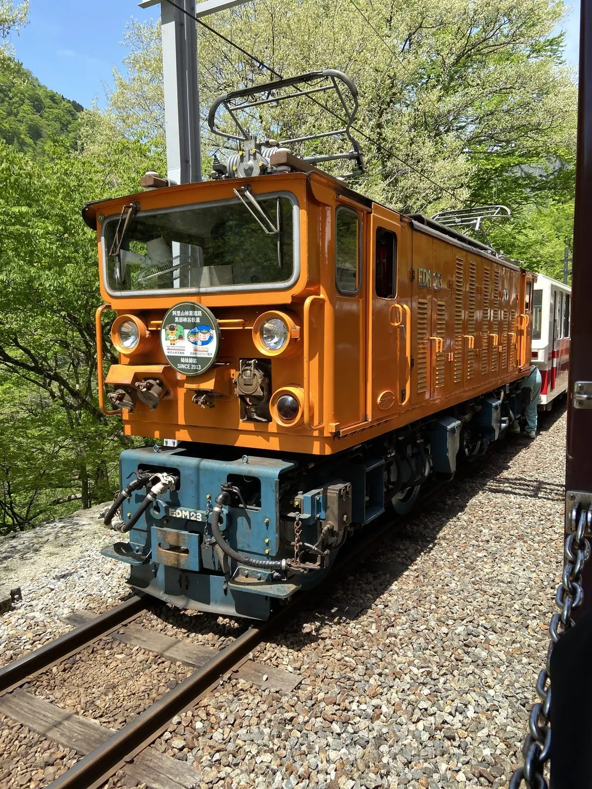 The orange electric locomotive of the Kurobe Gorge Railway at the Sasadaira turnaround