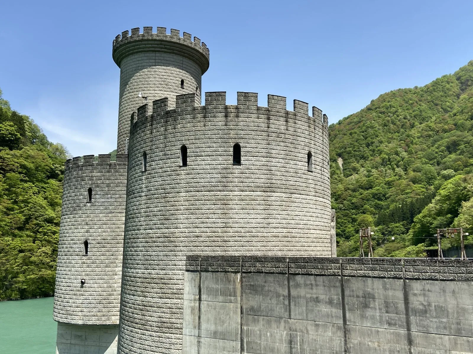 The castle-like towers of the Shin-Yanagawara power station on the lake